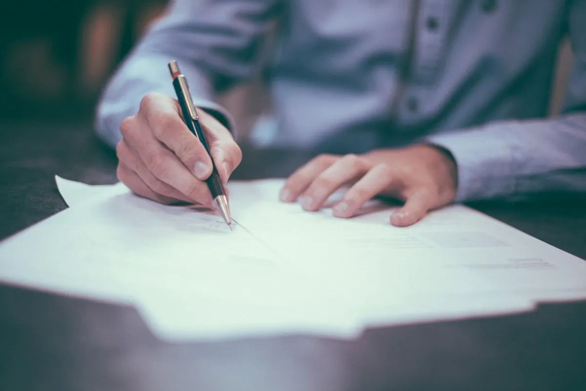 Immigration lawyer at London office desk reviewing visa application documents with client