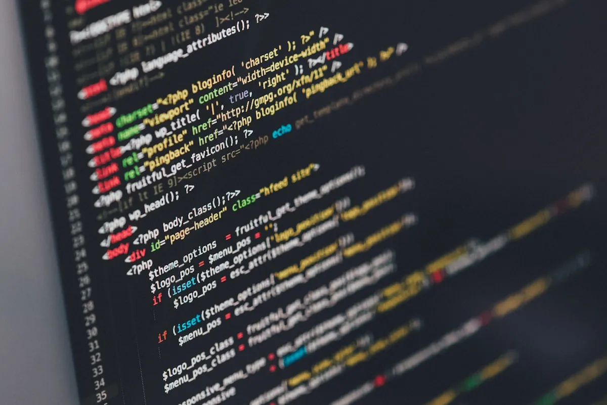 Web developer writing code on dual monitors in a professional London studio environment