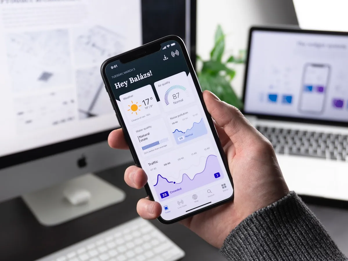 Developer reviewing mobile app interface on smartphone screen in professional London studio setting